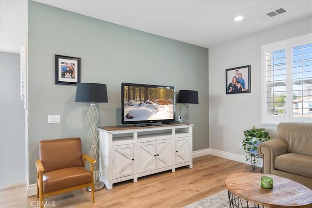 living room with light wood-style flooring, recessed lighting, visible vents, and baseboards