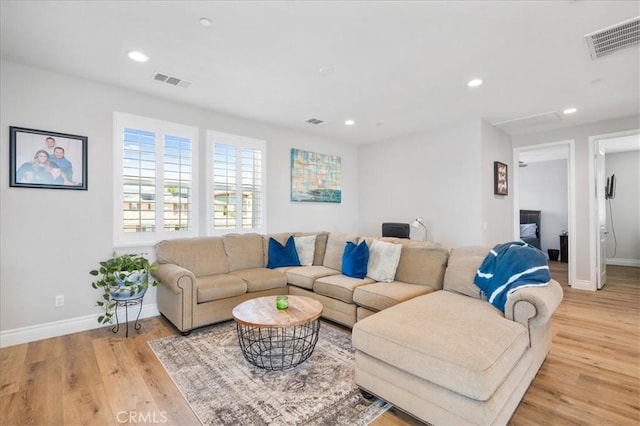 living room with light wood-type flooring, baseboards, visible vents, and recessed lighting