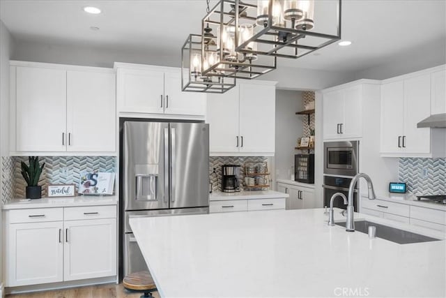 kitchen with stainless steel appliances, white cabinets, light countertops, and a sink