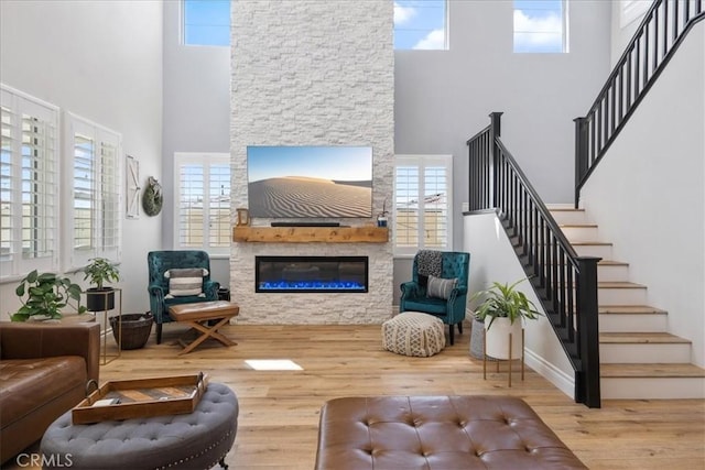 living room with stairs, a fireplace, and wood finished floors