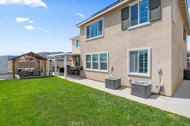 back of house with a lawn, an outdoor hangout area, cooling unit, a gazebo, and stucco siding