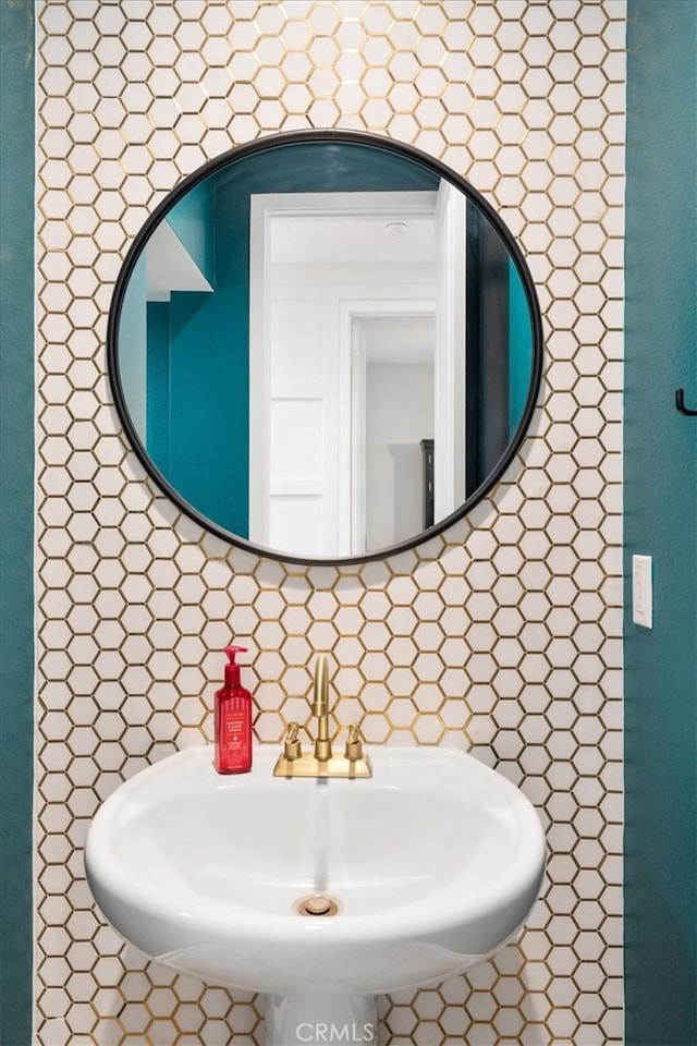 bathroom with tasteful backsplash and a sink