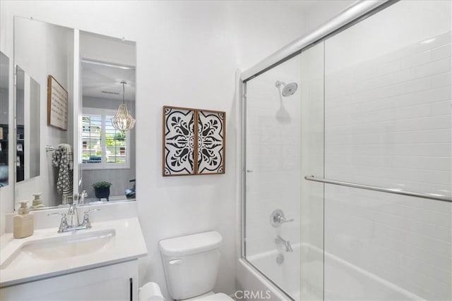 full bathroom with toilet, bath / shower combo with glass door, and vanity