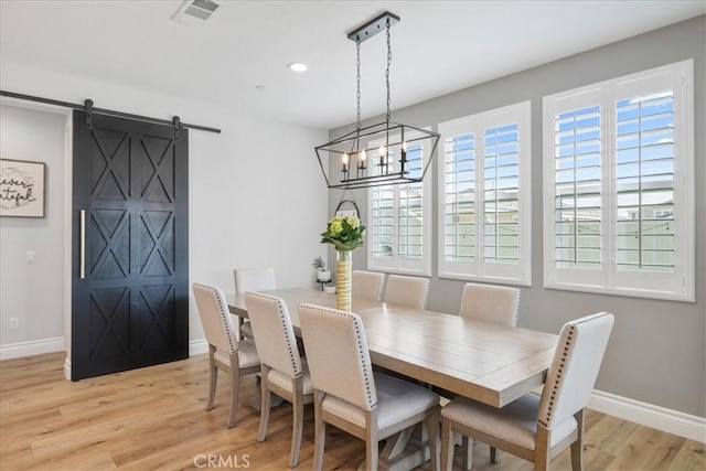 dining area with a barn door, recessed lighting, visible vents, baseboards, and light wood finished floors