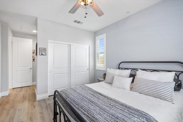 bedroom featuring light wood-style floors, a closet, visible vents, and baseboards