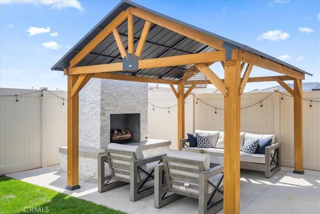 view of patio with a gazebo, a fenced backyard, and an outdoor living space with a fireplace