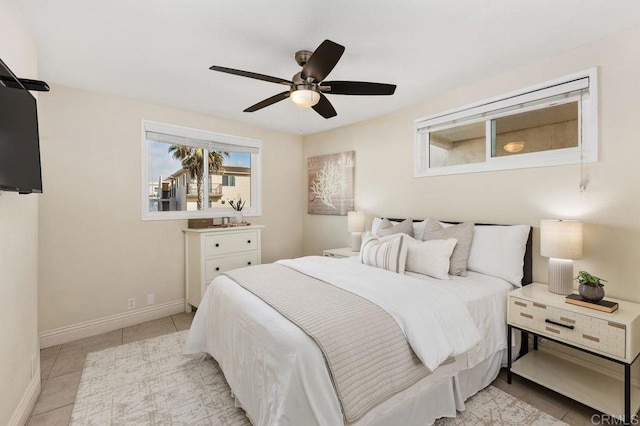 bedroom with a ceiling fan, baseboards, and light tile patterned floors