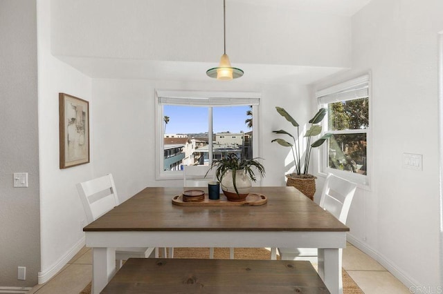 dining space with light tile patterned floors and baseboards