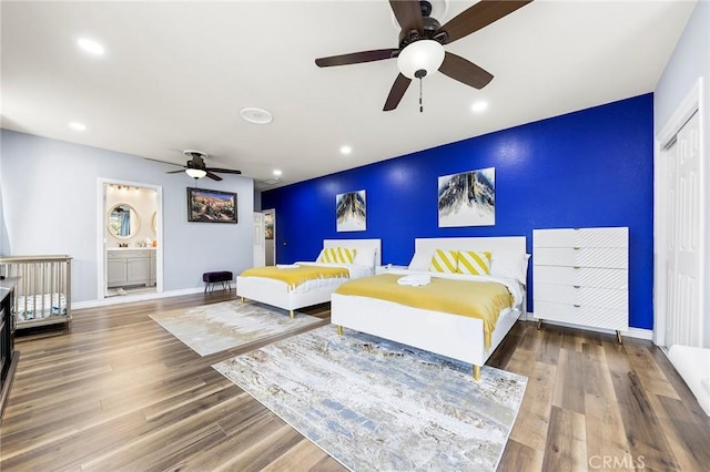 bedroom with baseboards, an accent wall, wood finished floors, and recessed lighting