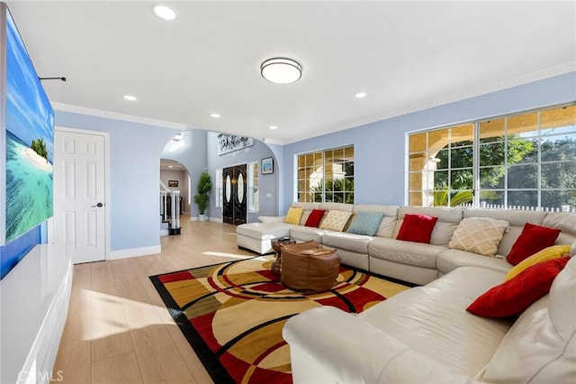 living room with crown molding, arched walkways, wood finished floors, and recessed lighting