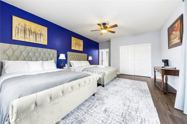 bedroom featuring baseboards, a closet, a ceiling fan, and wood finished floors