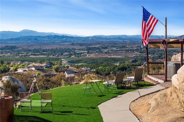 view of home's community with a lawn and a mountain view