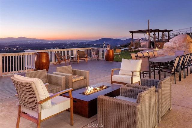 view of patio / terrace featuring an outdoor living space with a fire pit and a deck with mountain view