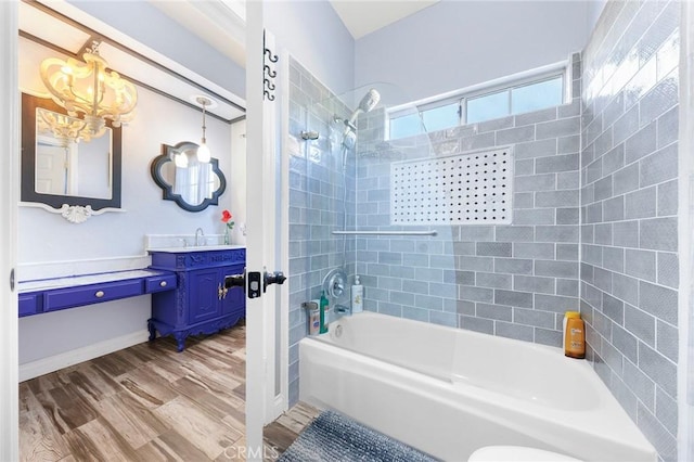 full bathroom featuring vanity, wood finished floors, and washtub / shower combination