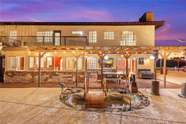 exterior space featuring a balcony, stucco siding, and a patio