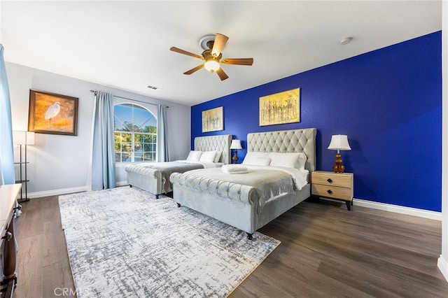 bedroom with a ceiling fan, visible vents, baseboards, and dark wood-type flooring