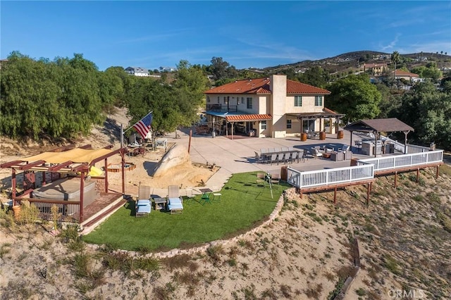 back of house with a patio, a chimney, fence, and a mountain view