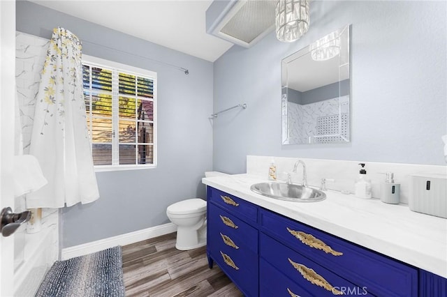 full bath featuring baseboards, toilet, wood finished floors, walk in shower, and vanity