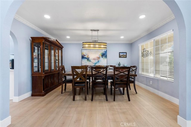 dining space with baseboards, arched walkways, crown molding, light wood-type flooring, and recessed lighting