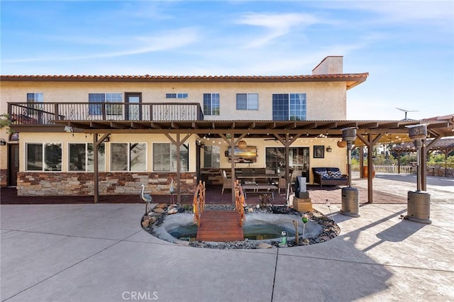 rear view of property featuring a patio area, a chimney, and stucco siding