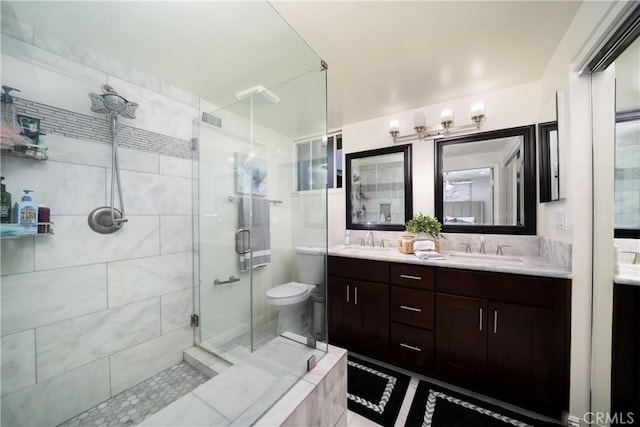 full bathroom featuring a shower stall, double vanity, visible vents, and a sink