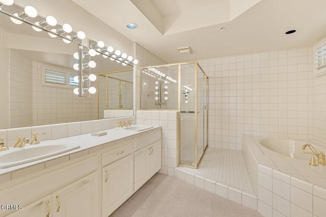 bathroom with a garden tub, a shower stall, a sink, and tile patterned floors