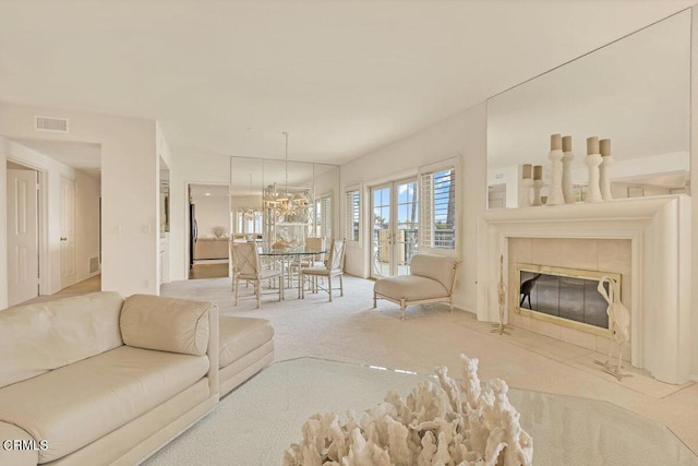 carpeted living room featuring visible vents, a tiled fireplace, and french doors