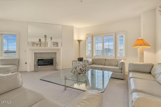 carpeted living room featuring a tiled fireplace