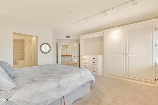 bedroom with light colored carpet, connected bathroom, and visible vents