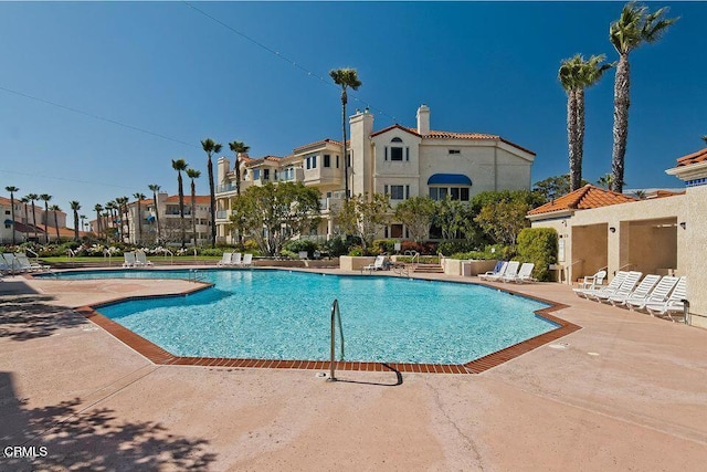 community pool featuring a residential view and a patio area