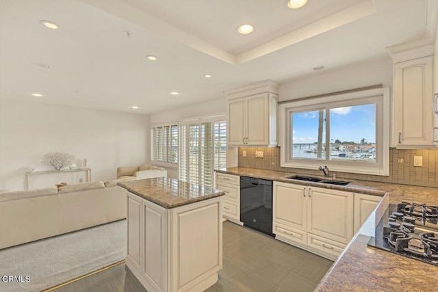 kitchen featuring open floor plan, black appliances, a sink, and a healthy amount of sunlight