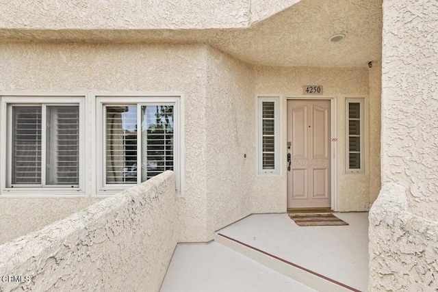 view of exterior entry with stucco siding