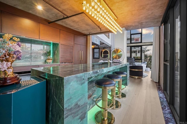 bar with a wall of windows, oven, and hardwood / wood-style flooring