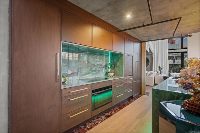 kitchen with black electric stovetop, wood finished floors, and oven