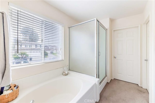 bathroom featuring a stall shower and a garden tub