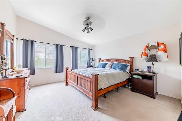 bedroom with lofted ceiling, light colored carpet, and baseboards