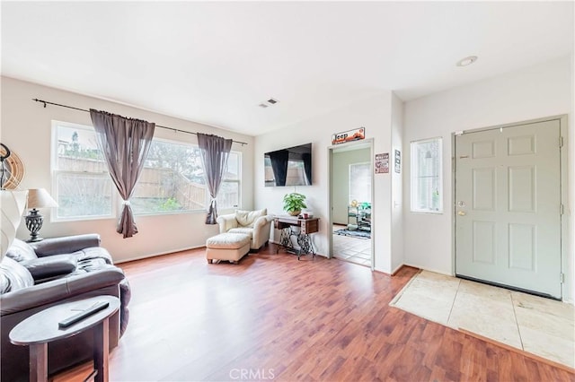 living area featuring visible vents and wood finished floors