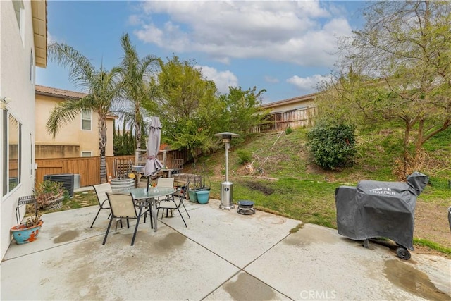 view of patio / terrace featuring a fenced backyard, a grill, outdoor dining area, and central AC