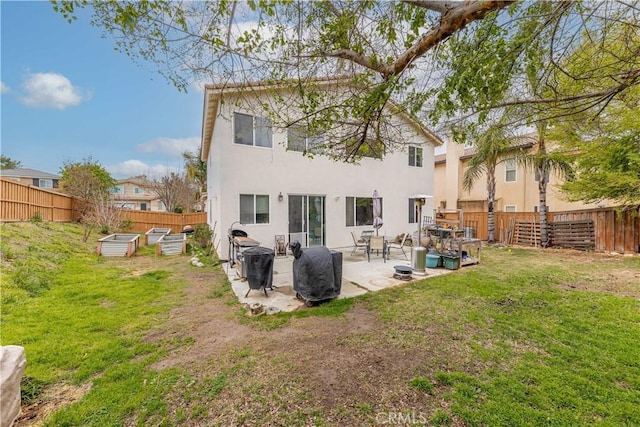 rear view of property featuring a yard, a patio area, a fenced backyard, and stucco siding