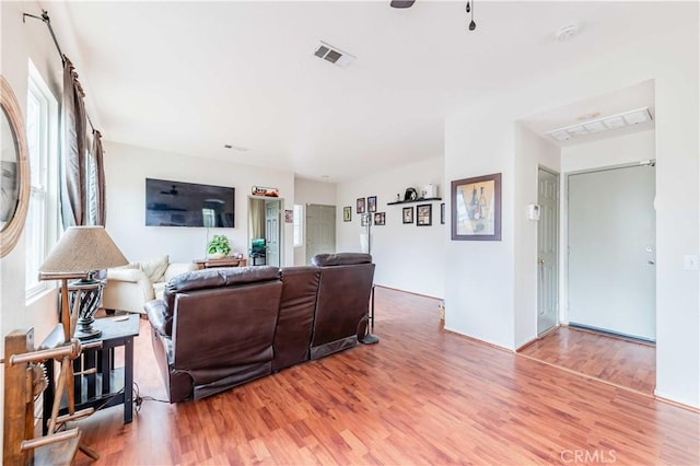 living room featuring visible vents and wood finished floors