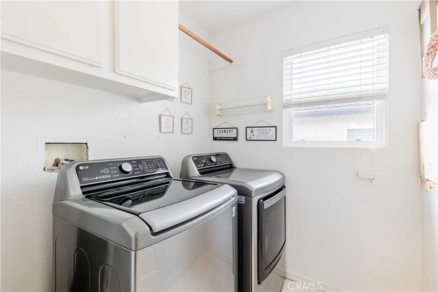 washroom with cabinet space and washer and dryer