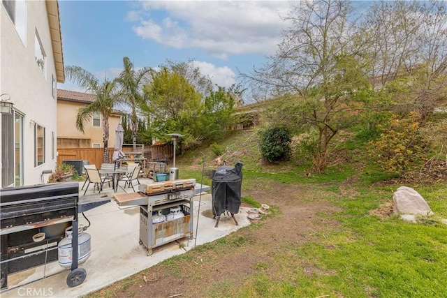 view of yard featuring a patio area, fence, and outdoor dining space