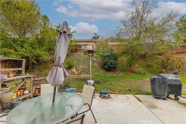 view of patio with outdoor dining space, a fenced backyard, and a grill