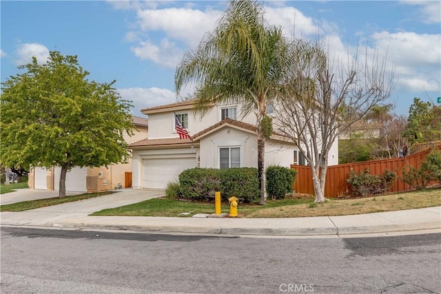 view of front of home featuring an attached garage, fence, a tile roof, concrete driveway, and stucco siding