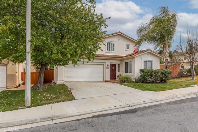 view of front facade with a garage, concrete driveway, a tiled roof, fence, and stucco siding