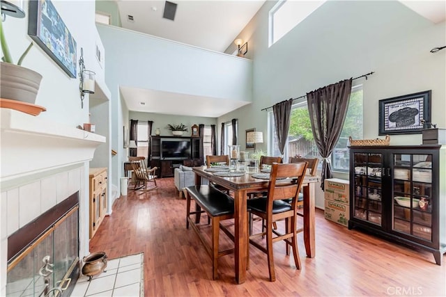 dining space with light wood-style flooring, a fireplace, and visible vents