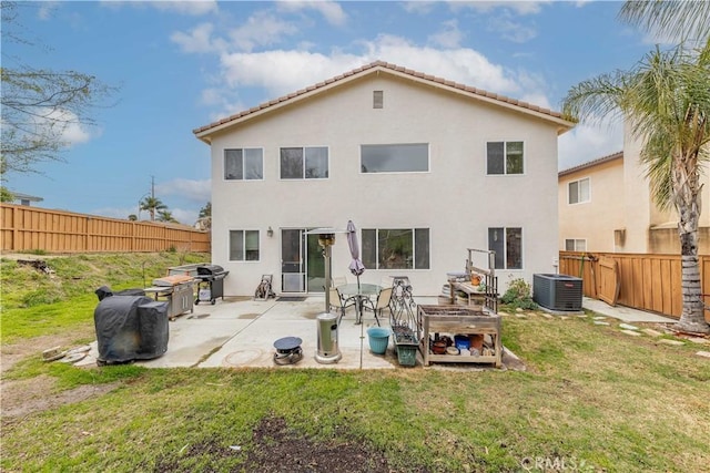 back of property featuring a lawn, a patio, a fenced backyard, cooling unit, and stucco siding