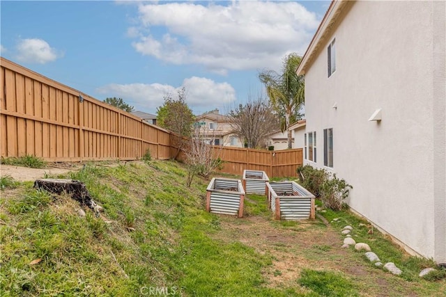 view of yard featuring a fenced backyard and a vegetable garden