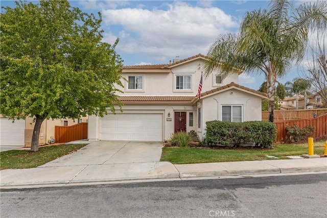 mediterranean / spanish house with concrete driveway, a tile roof, fence, and stucco siding