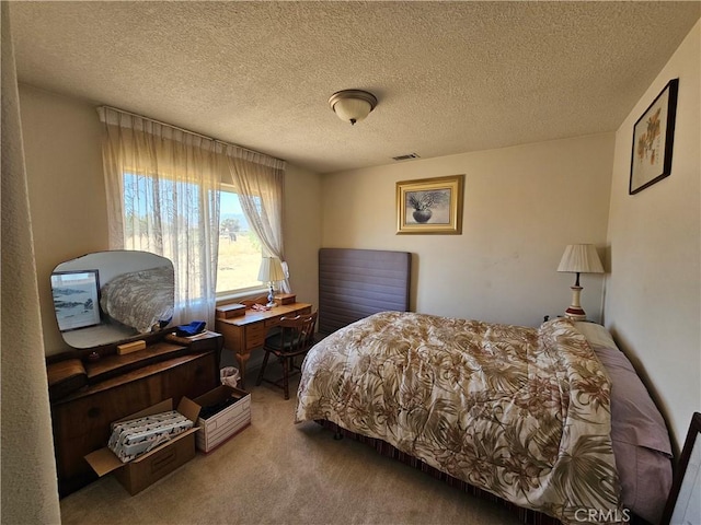 carpeted bedroom with a textured ceiling and visible vents